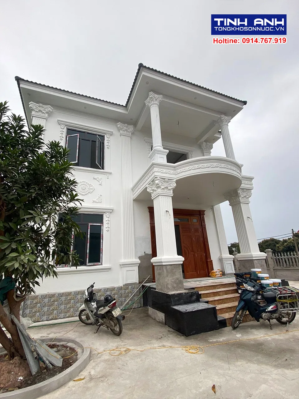 Thi công sơn nhà 2 tầng sử dụng mã màu sơn trắng sứ cùng khung cửa sổ đen và cửa gỗ nâu